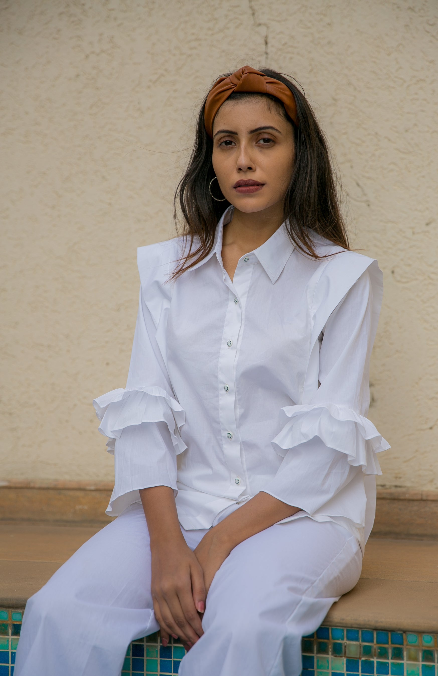 PLEATED FLUTTER SLEEVES SHIRT - A shirt with pleats on the body and frill sleeves is a garment that combines two design elements to create a unique and eye-catching style. It is made of lightweight and breathable fabric.