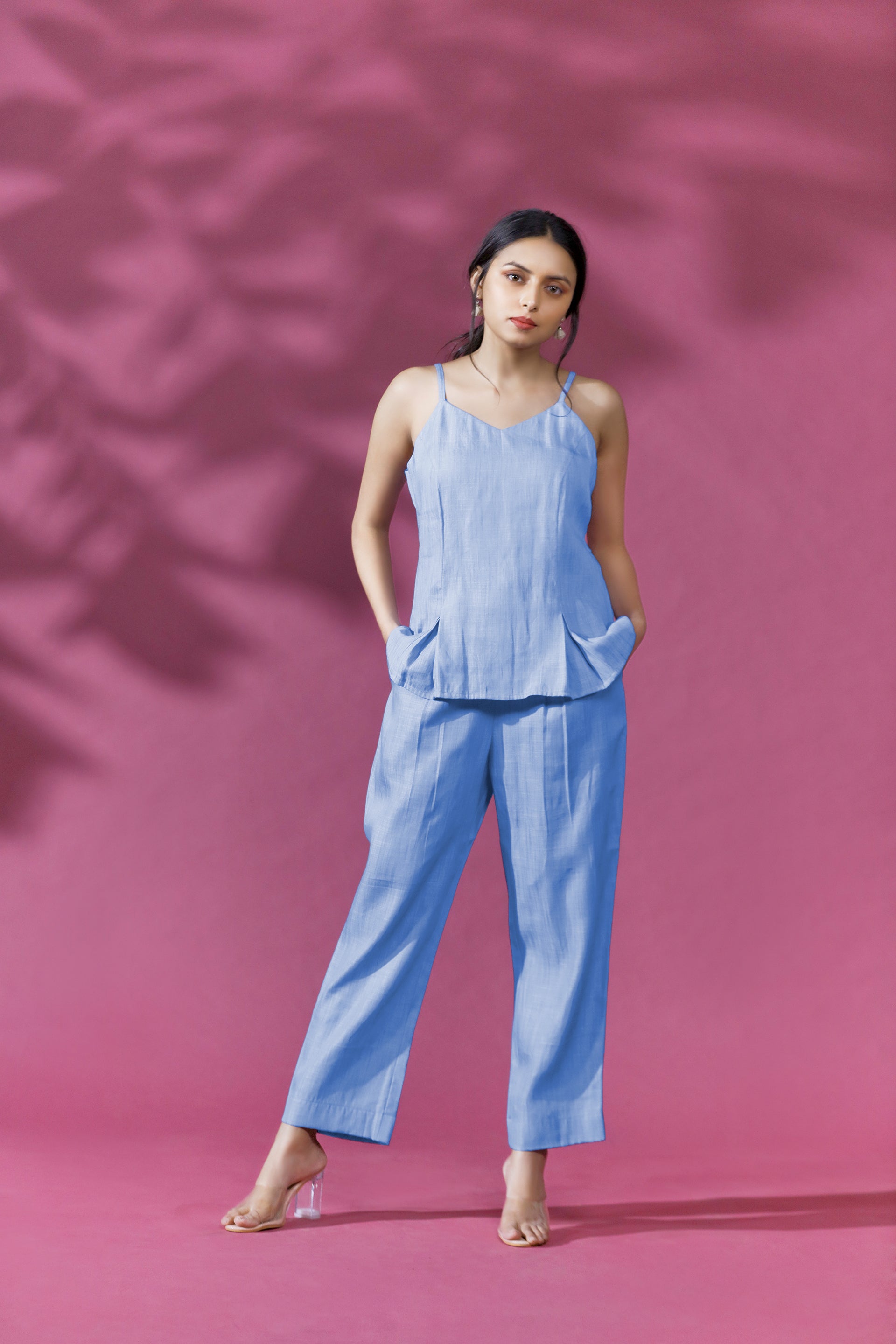 SWEETHEART COORD SET - This is a stylish and versatile ensemble that features a sleeveless top and pants in a soft shade of blue. The top has a corset look , with a V neckline and a flattering fit that flows effortlessly over the body. The pants are also made from the same chambray blue fabric as the top, creating a cohesive and stylish look when worn together.